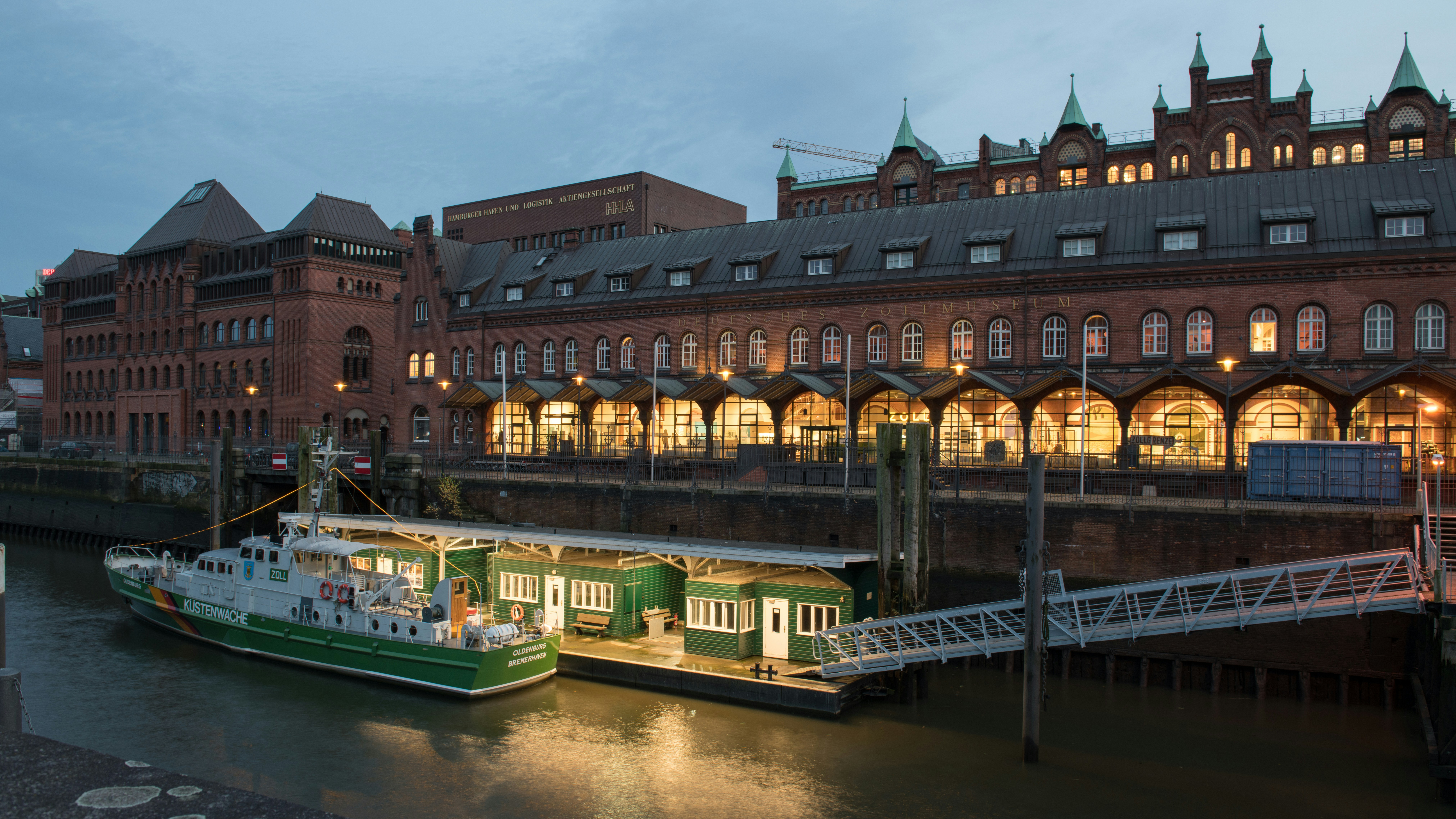 Two boats are docked in front of a large building
